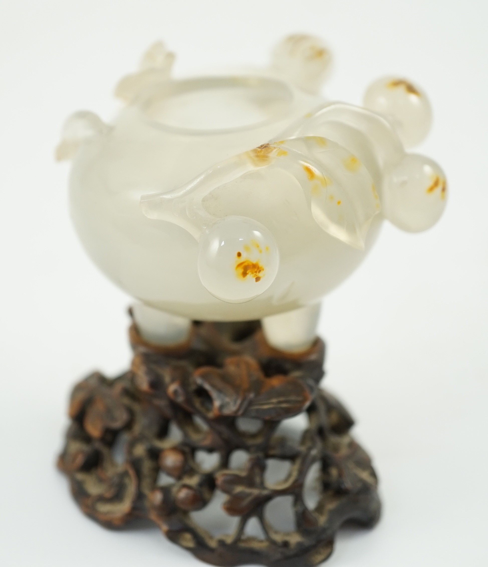 A Chinese small carved agate brushwasher on wooden stand, 19th century, 8.5cm high including stand